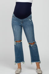 woman wearing a light blue distressed maternity jeans with a black belly band and frayed hems