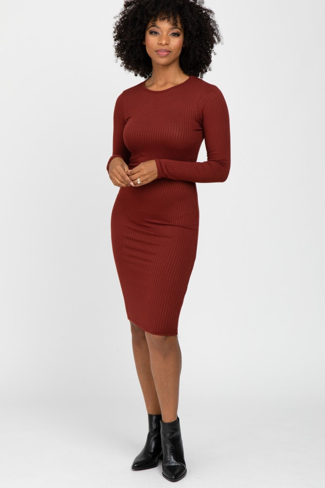 Woman wearing a long-sleeve burgundy ribbed bodycon midi dress and black ankle boots against a white background