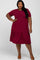 Plus size woman wearing a short sleeve burgundy ribbed tiered midi dress with brown sandals