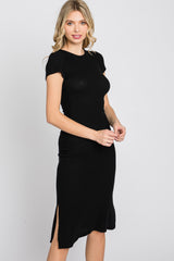 woman wearing a short sleeve black ribbed midi dress with a side slit against a white background