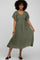 woman wearing a short sleeve olive green midi dress with a v-neck and tiered hem, smiling at the camera