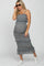 Pregnant woman in a blue floral smocked maternity midi dress with ruffles, sunglasses, and white sneakers