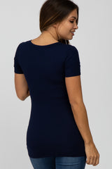 woman wearing a navy blue short sleeve maternity top with a fitted style