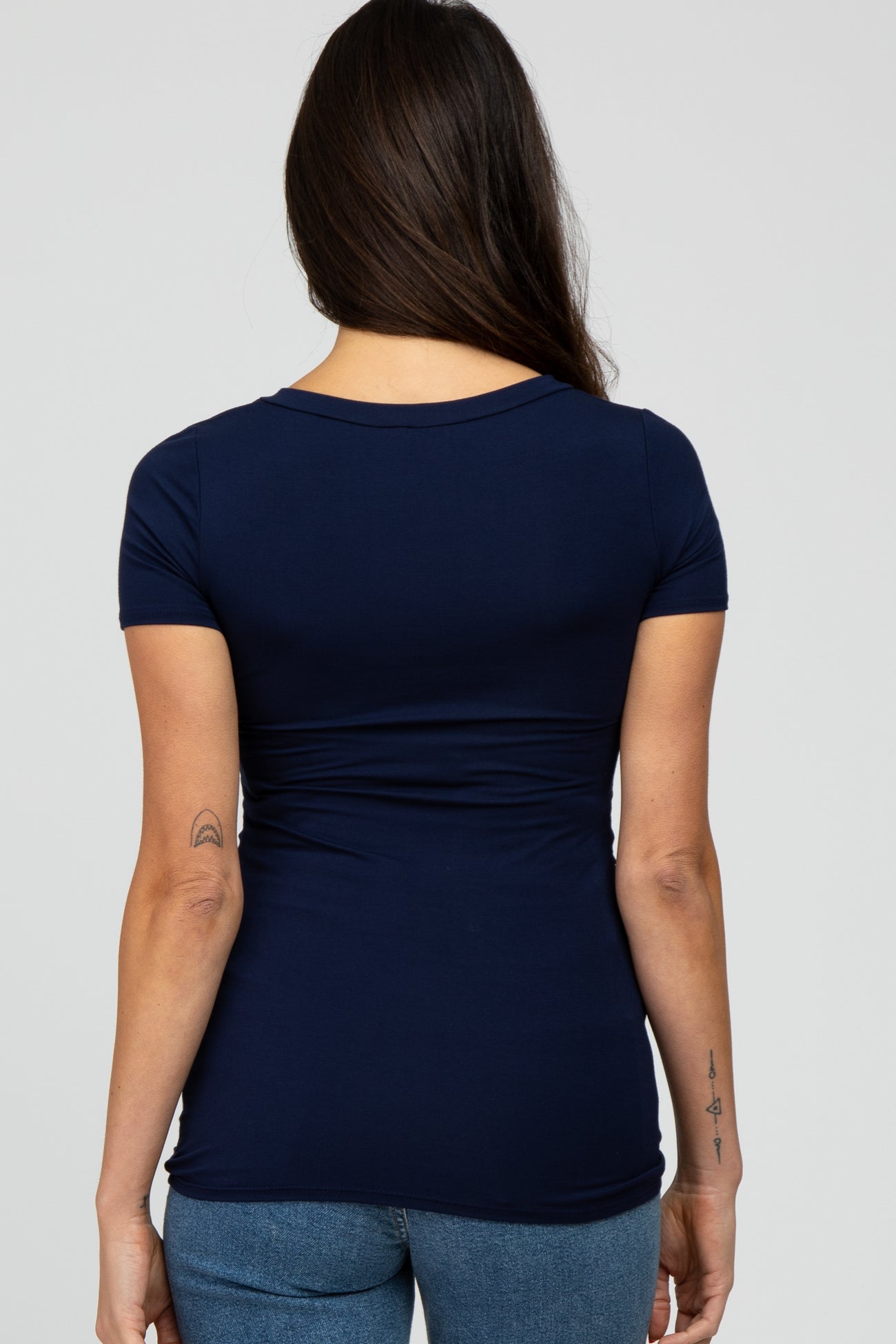 woman wearing a navy blue short sleeve fitted top with a rounded neckline and a flattering silhouette