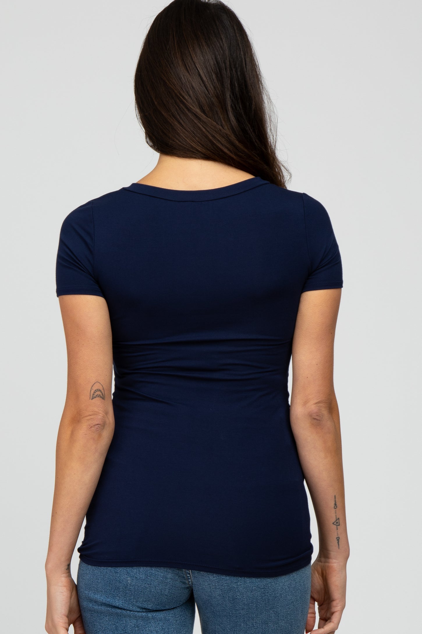 woman wearing a navy blue short sleeve fitted top with a rounded neckline and a flattering silhouette