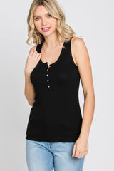 woman wearing a black sleeveless henley top with button detailing and light blue jeans