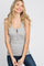 smiling woman with blonde wavy hair wearing a grey ribbed henley tank top and blue jeans