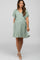 woman wearing a mint green maternity dress with flutter sleeves and a flowing skirt, showcasing her baby bump