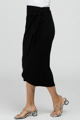 woman wearing a black midi wrap skirt with a side tie and snakeskin print block heel sandals