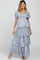 Woman wearing a purple and blue floral tiered maxi dress with puff sleeves and a smocked bodice