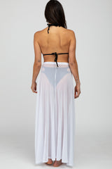 woman wearing a black bikini top and a sheer white long skirt, viewed from the back