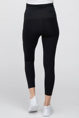 Rear view of person wearing black high-waisted maternity leggings and white sneakers