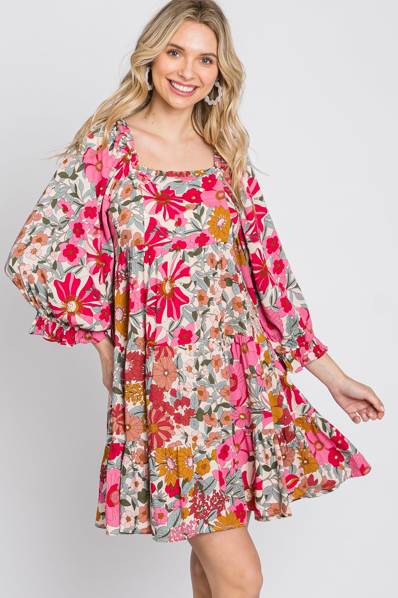 woman wearing a pink floral print babydoll dress with long puff sleeves and a square neckline