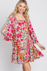 woman wearing a pink floral print babydoll dress with long puff sleeves and a square neckline