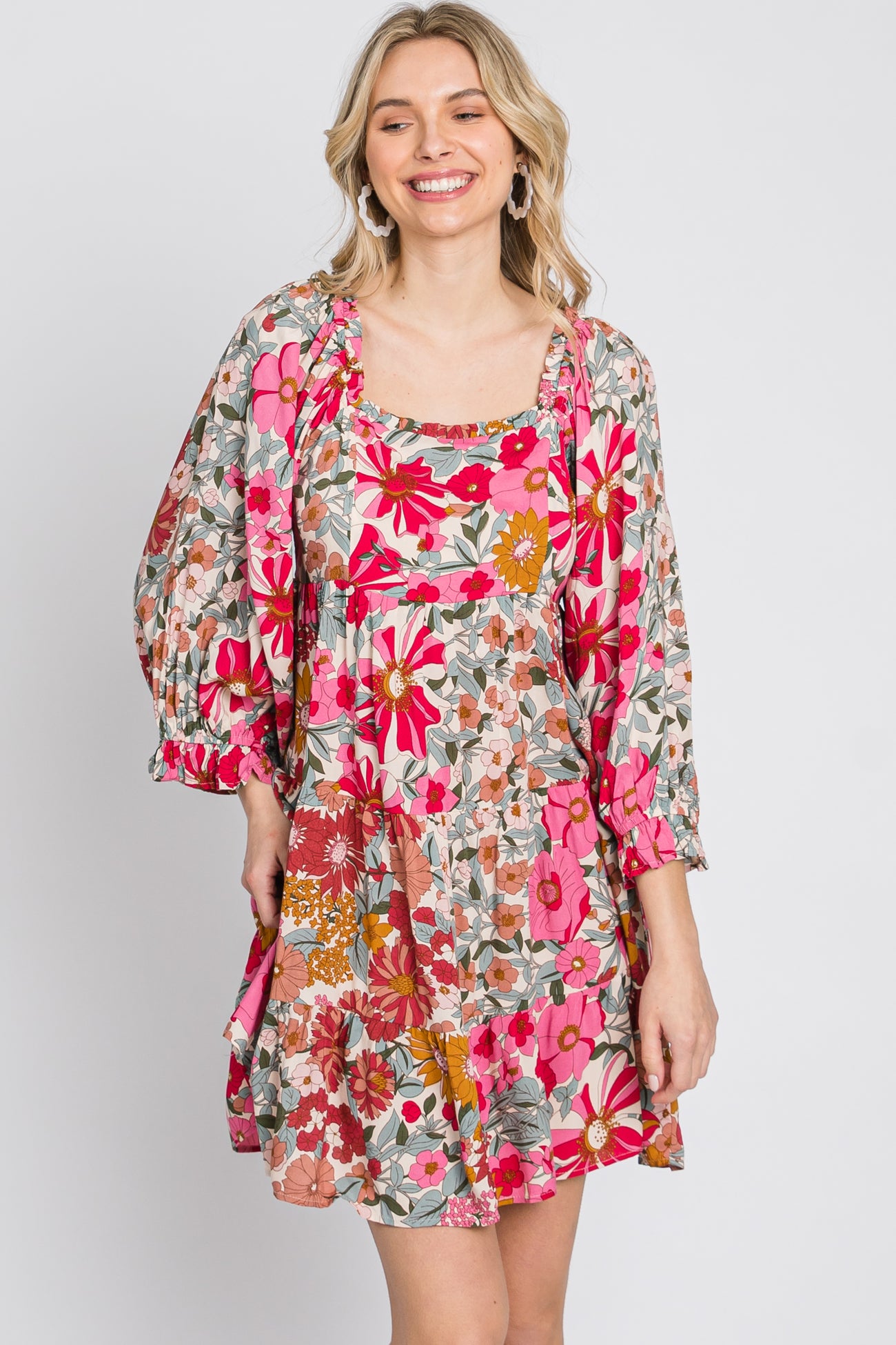 woman wearing a pink and tan floral print babydoll dress with square neckline and puff sleeves