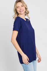 woman wearing a navy blue short sleeve top with a relaxed fit and round neckline paired with light blue jeans
