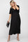 woman wearing a black maternity dress with a tie front and flutter sleeves, holding a black clutch and showing her baby bump