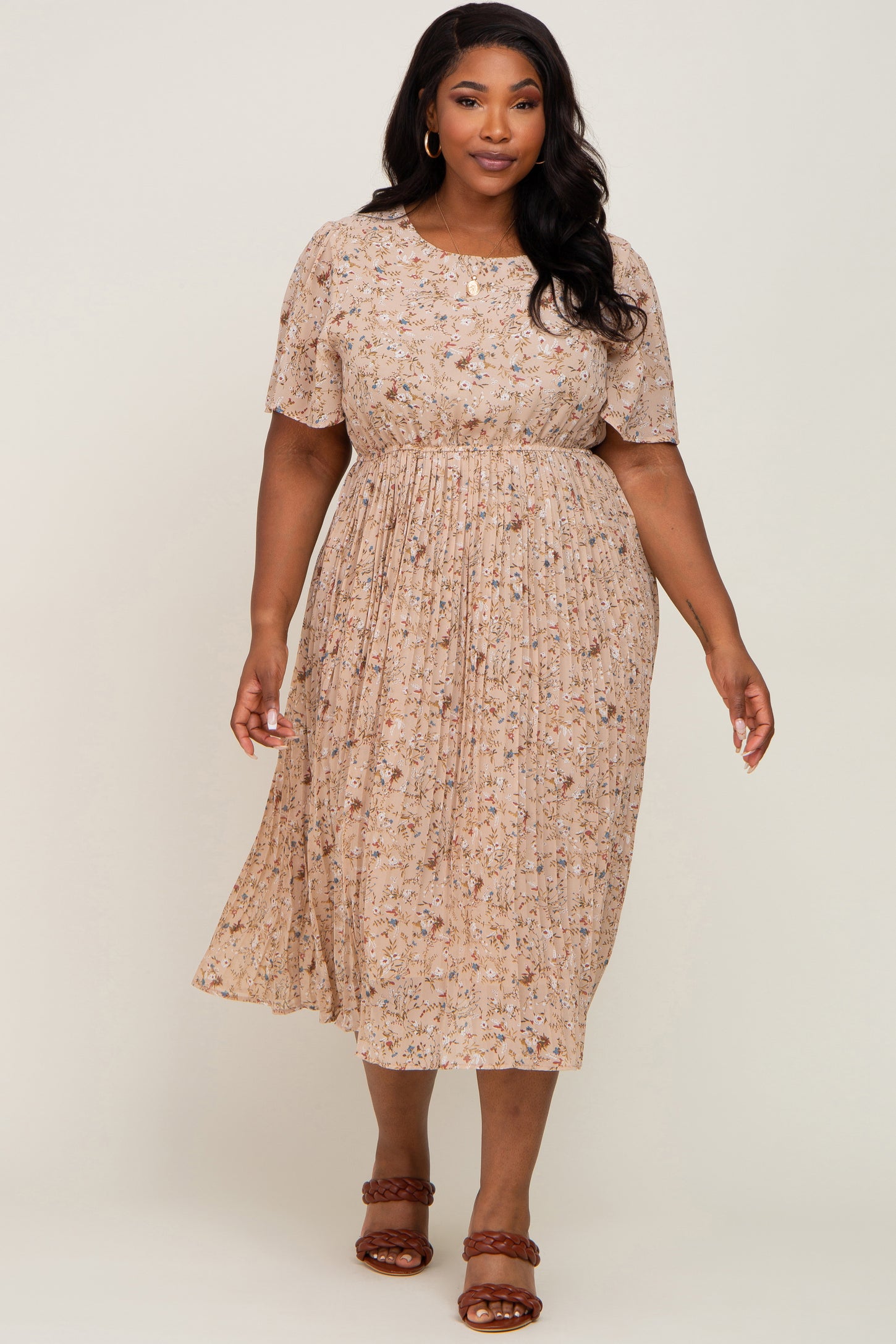 Plus size woman wearing a beige floral midi dress with flutter sleeves and a pleated skirt