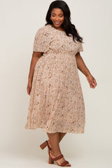 woman wearing a beige floral plus-size midi dress with short sleeves and a smocked waist, paired with brown heeled sandals