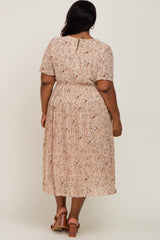 woman wearing a light pink floral plus size midi dress with short sleeves and pleated skirt from the back