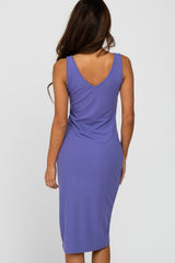 woman wearing a fitted purple ribbed midi dress with a deep V-back design