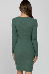 woman wearing a green long sleeve ribbed maternity dress, showing the back view