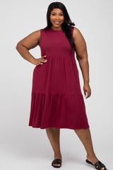 plus size woman wearing a sleeveless burgundy tiered midi dress and black sandals