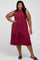 plus size woman wearing a sleeveless burgundy tiered midi dress and black sandals