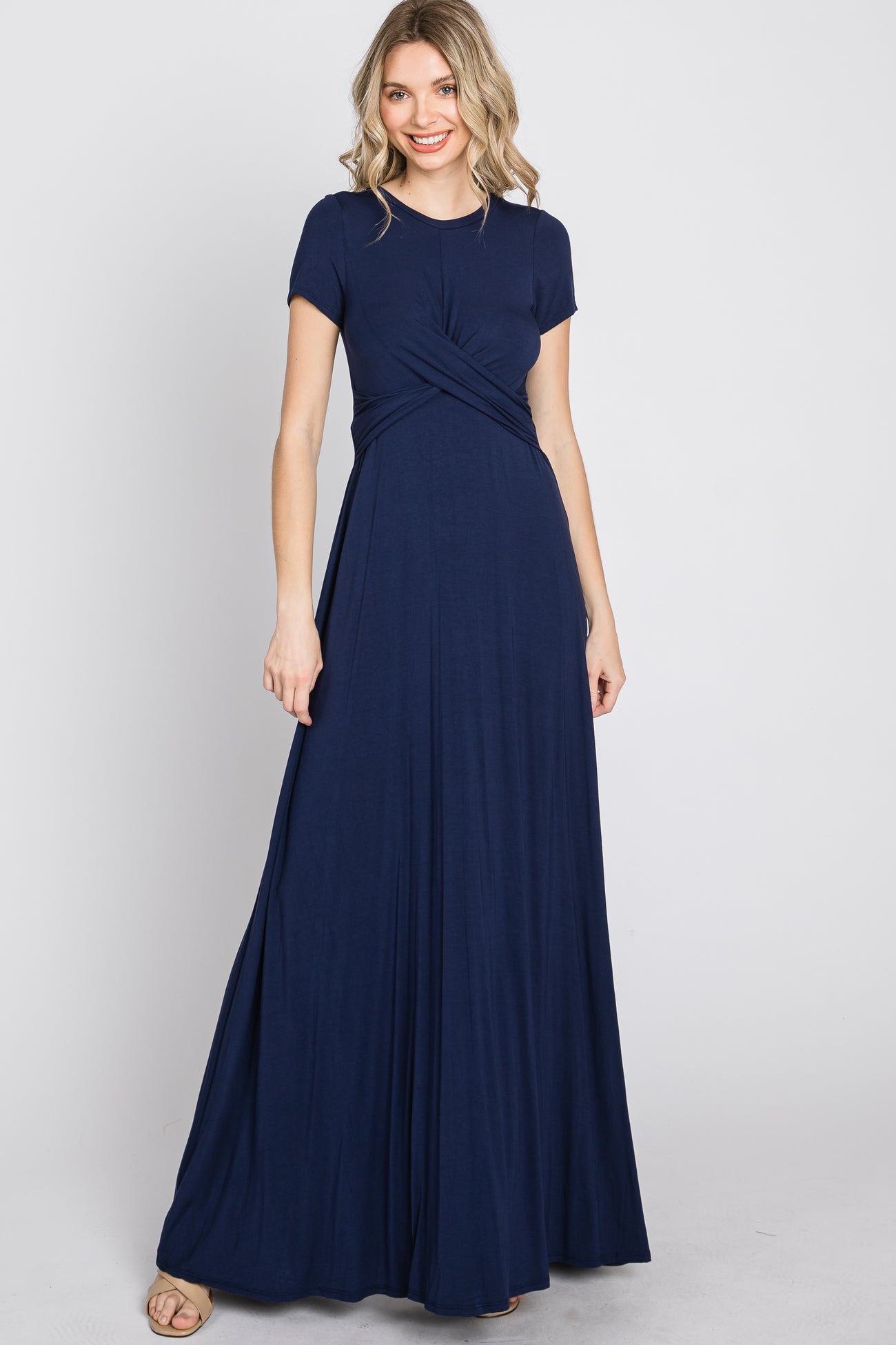 woman wearing a navy blue short sleeve maxi dress with a twisted front design