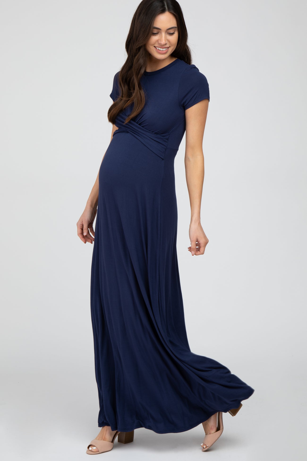 woman wearing a navy blue short sleeve maternity maxi dress, showcasing her baby bump