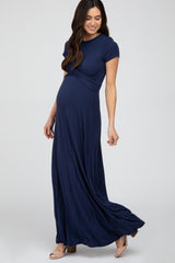 woman wearing a navy blue short sleeve maternity maxi dress, showcasing her baby bump