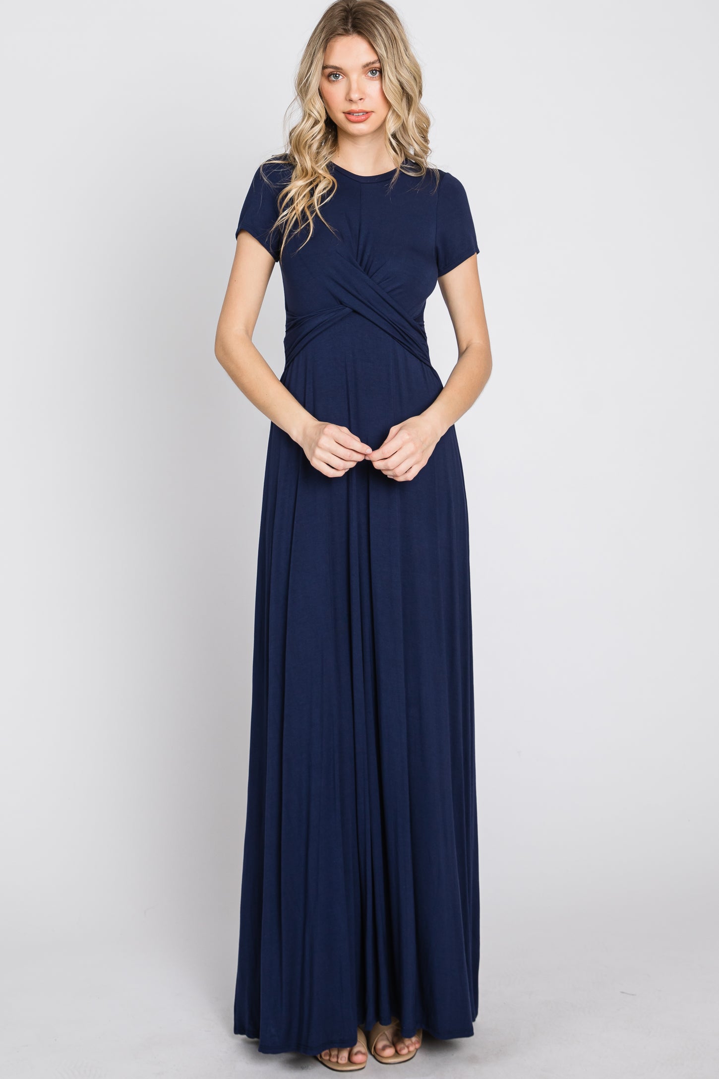 woman wearing a navy blue short sleeve maxi dress with a twisted front detail