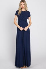 woman wearing a navy blue short sleeve maxi dress with a twisted front detail