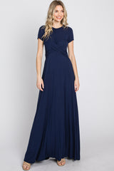 woman wearing a navy blue short sleeve maxi dress with a wrap front and flowing skirt