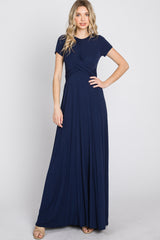woman wearing a navy blue short sleeve maxi dress with a twisted front detail
