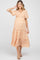 woman wearing a short sleeve orange floral maternity dress with a tiered skirt and a baby bump visible