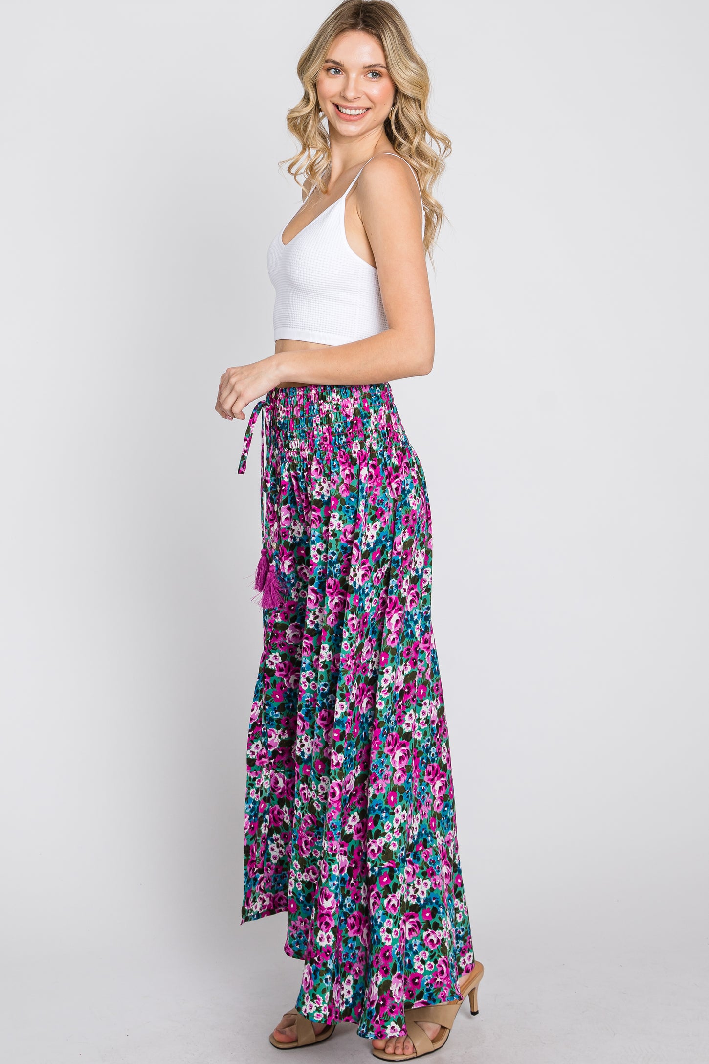 woman wearing white crop top and purple floral wide leg palazzo pants with smocked waist