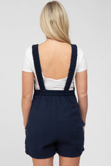 woman wearing a navy blue maternity romper with a fitted back and ruffled straps