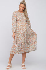 pregnant woman wearing a long sleeve floral tiered maternity midi dress with cream block heel sandals