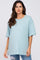 woman wearing a light blue oversized maternity t-shirt and distressed jeans, showing a baby bump
