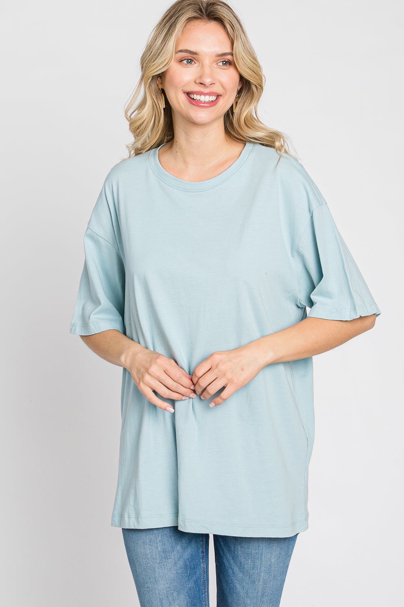 woman wearing a light blue oversized t-shirt with short sleeves and smiling