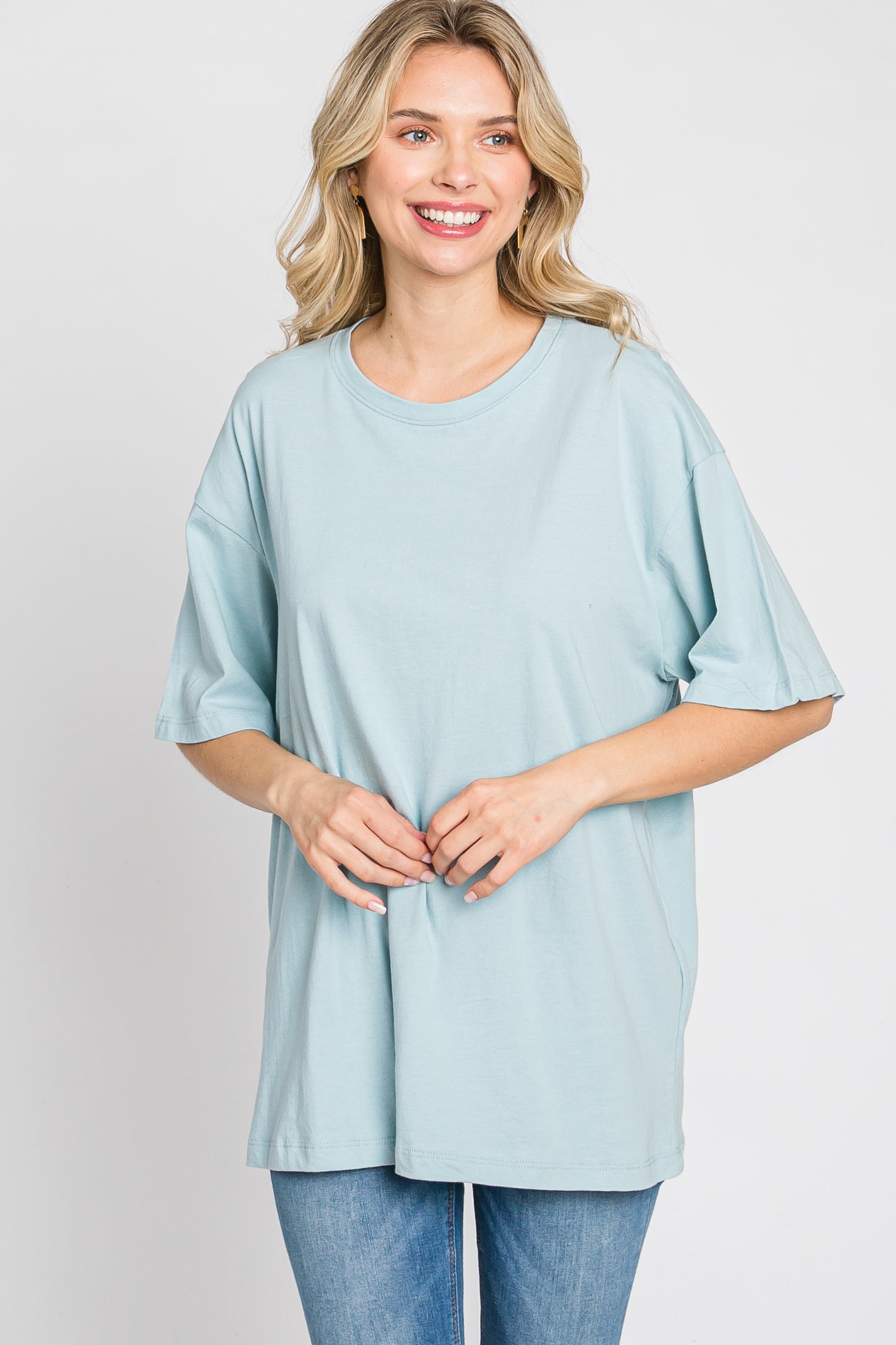 woman wearing a light blue oversized t-shirt with short sleeves and smiling