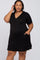 woman wearing a black maternity plus dress with a v-neck and ruffled hem, highlighting her baby bump