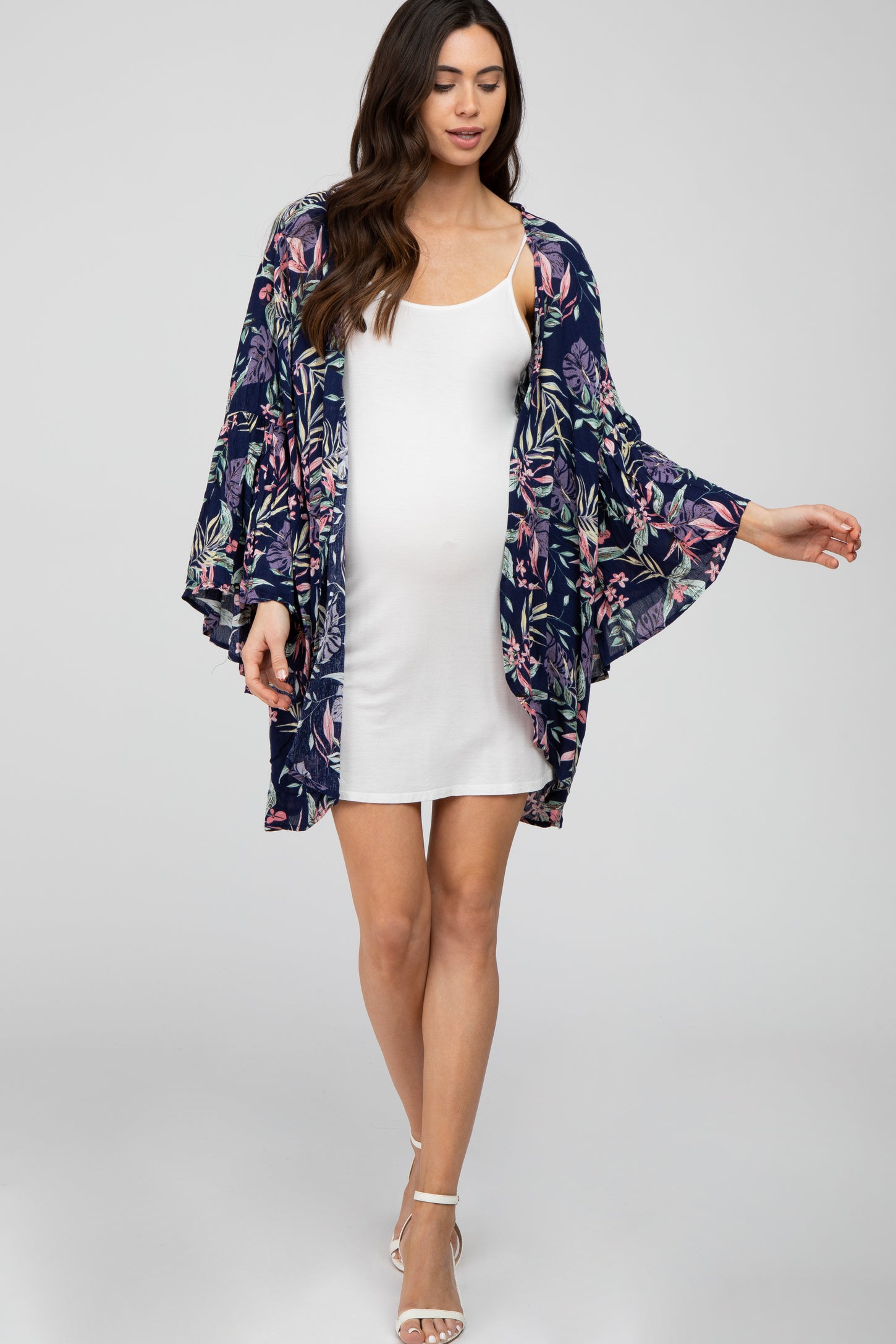 woman wearing a white maternity dress and a floral navy kimono, baby bump visible