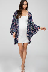 woman wearing a white maternity dress and a floral navy kimono, baby bump visible