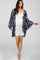 woman wearing a white maternity dress and a floral navy kimono, baby bump visible