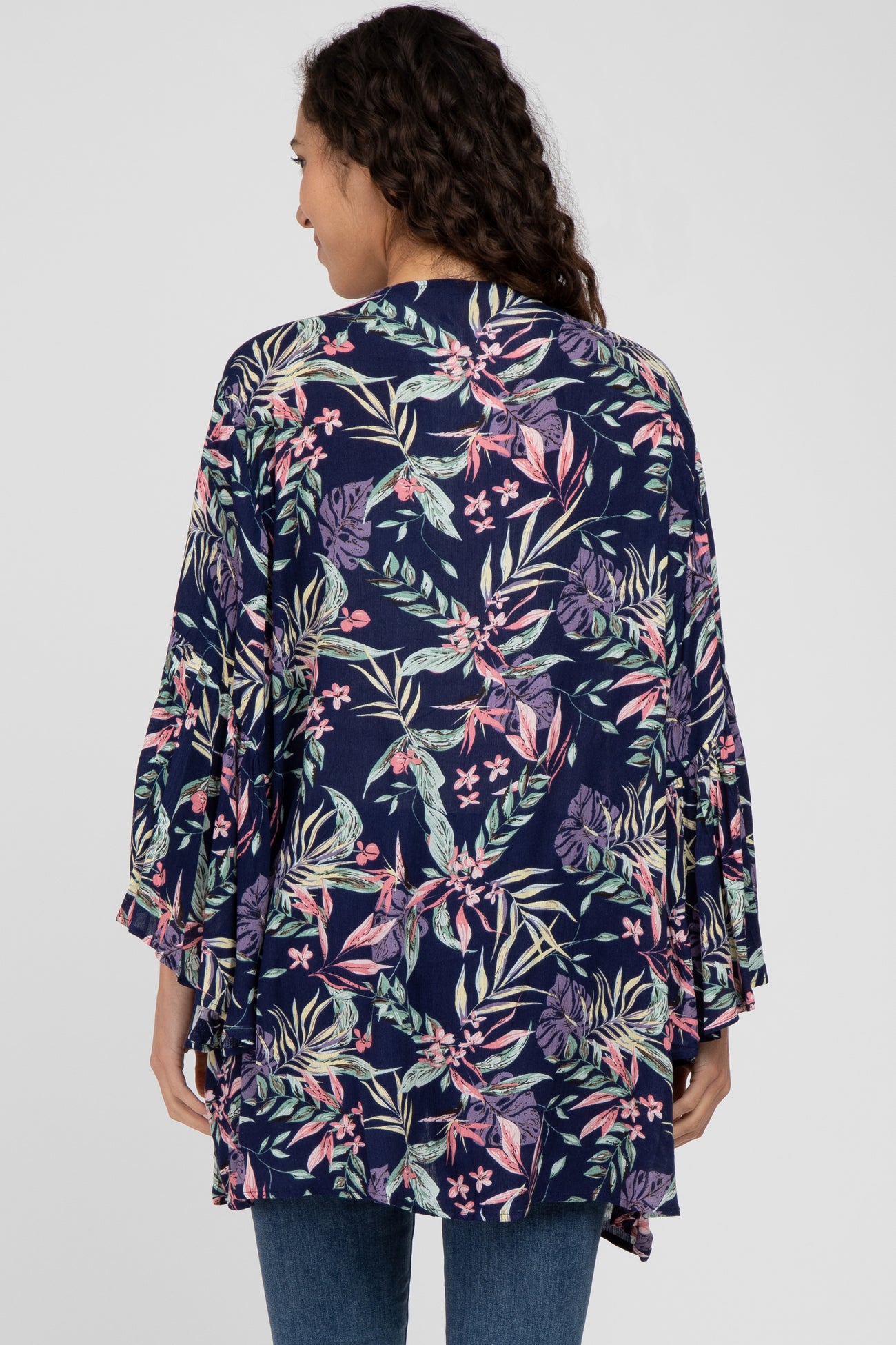 woman wearing a navy floral kimono with bell sleeves and a relaxed fit