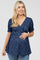 Pregnant woman wearing a navy blue floral maternity top with short puff sleeves and a wrap neckline
