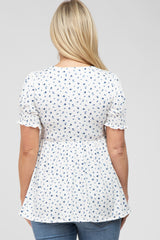 woman wearing a white floral maternity top with short sleeves and a flowy silhouette, viewed from the back