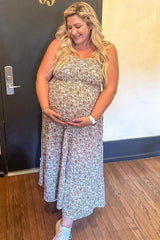 woman wearing a floral maternity maxi dress and holding her baby bump